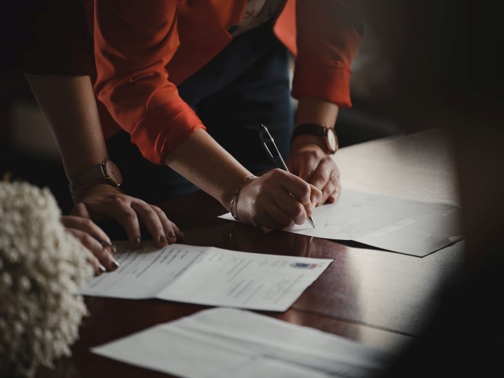 Two people filling out paperwork at a rehab in Nottingham