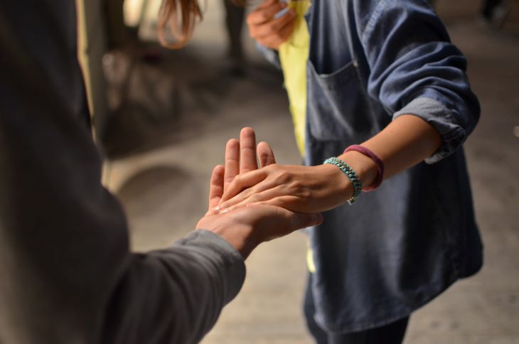 A man talking another man's hand in support in Reading