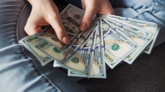 A person counting notes while saving money giving up drinking