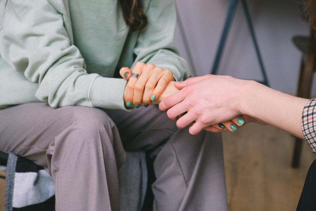 person holding woman's hand in support