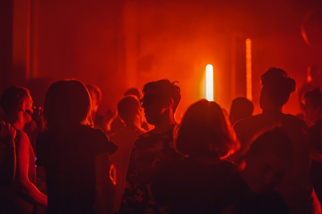 Red lit nightclub and silhouettes before alcohol rehab Blackburn