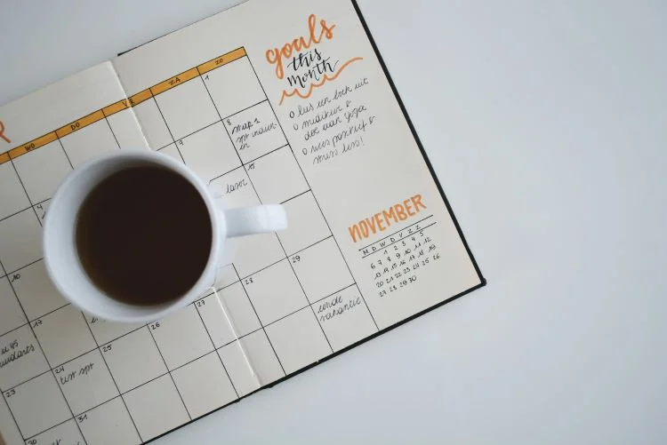 A calendar with goals set and a mug of coffee on top in Nottingham