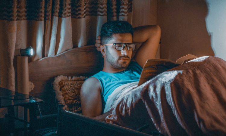 A man reading in bed in London