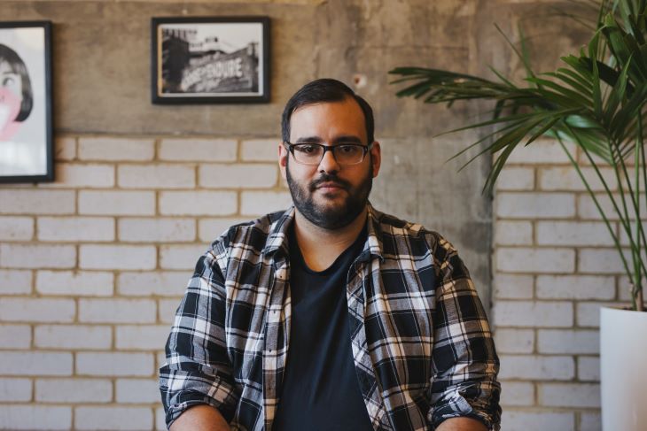 A middle aged man looking into the camera with a neutral expression