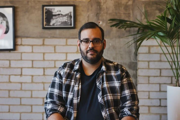 A middle aged man looking into the camera with a neutral expression