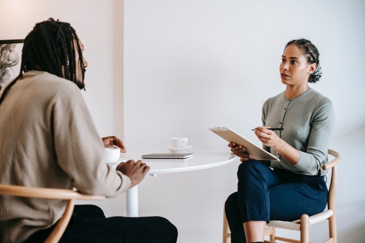 A male patient talking to a female therapist at a rehab in Manchester