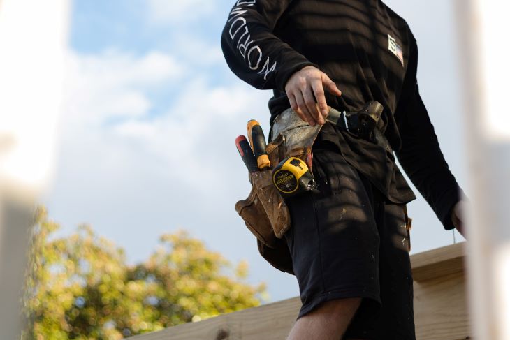 A builder at work with tools on his belt in Warwickshire