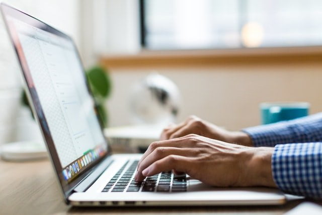 Man typing on a laptop at a drug and alcohol rehab clinic in Lancashire