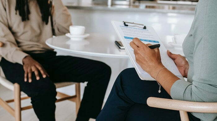 Therapist speaking with a patient and taking notes at a drug and alcohol rehab in Edinburgh