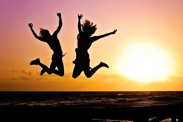 Two people jumping at a sunset a drug and alcohol rehab in Lancashire