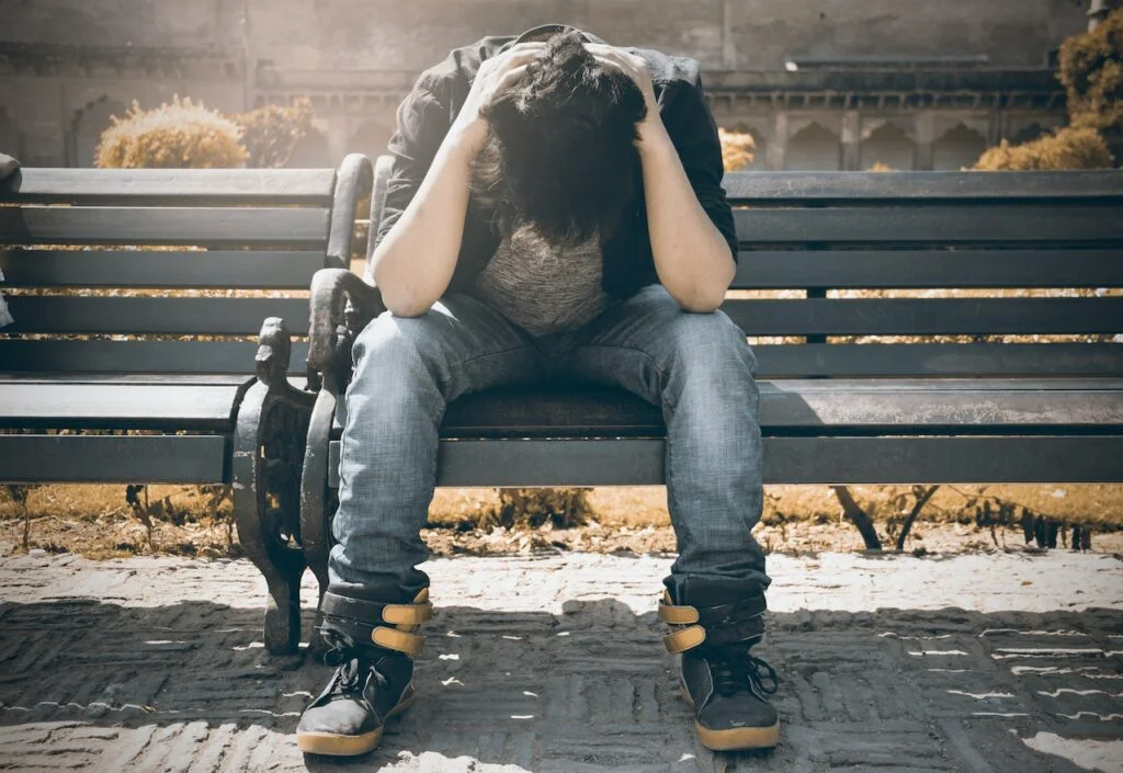 A man with his head in his hands on a bench in Staffordshire