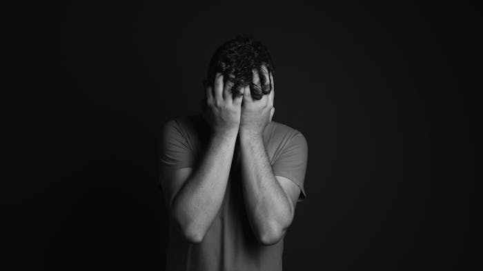 Black and white photo of a man feeling the side effects of phenibut addiction