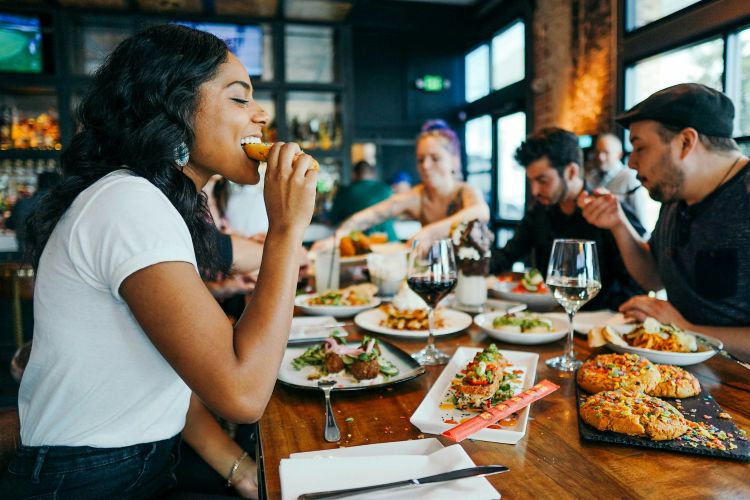 Four people eating at a wooden table